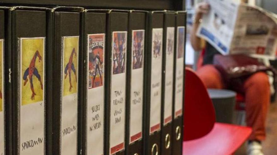 Una mujer lee la prensa junto al área de cómics de una biblioteca coruñesa. / 13fotos