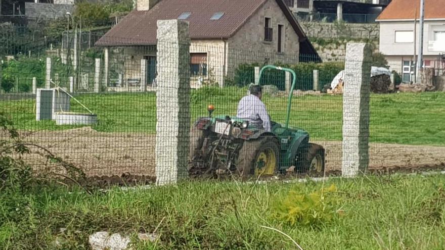 Un hombre arando la tierra con su tractor, en Pontearnelas, esta mañana.