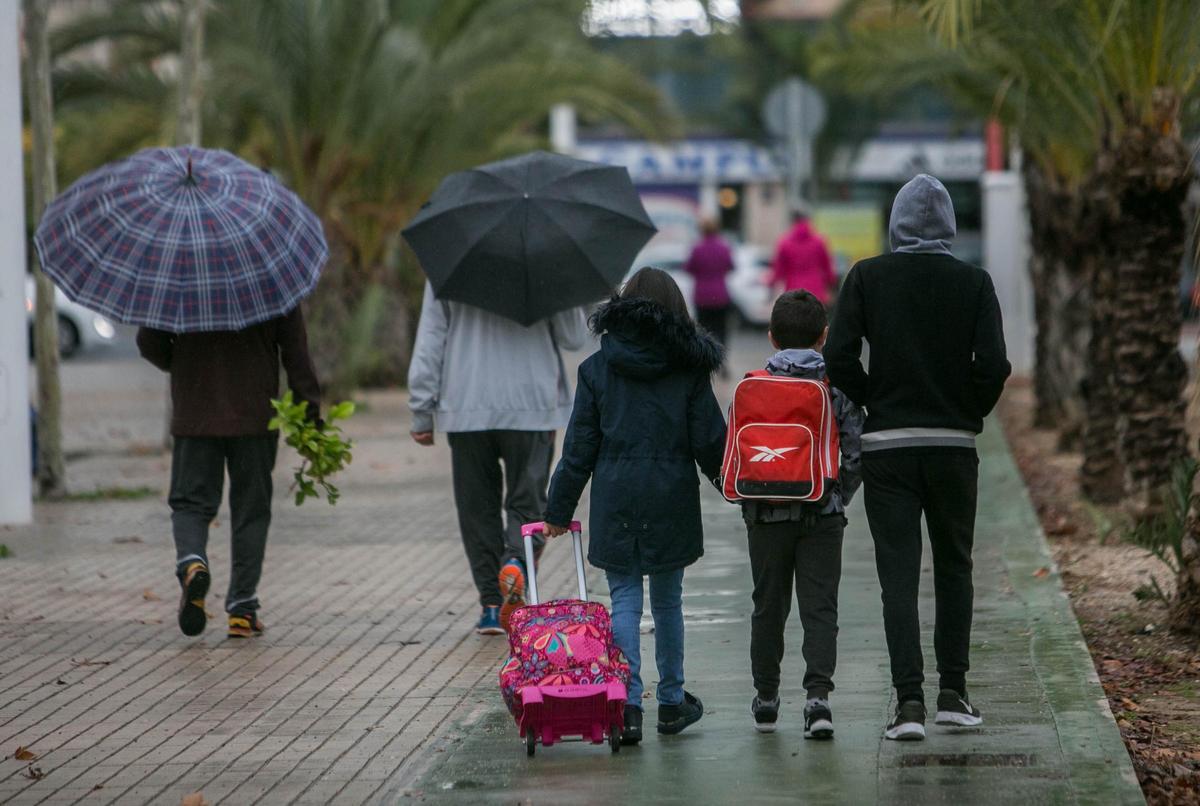 Escolares de camino a clase, en un día de lluvia.
