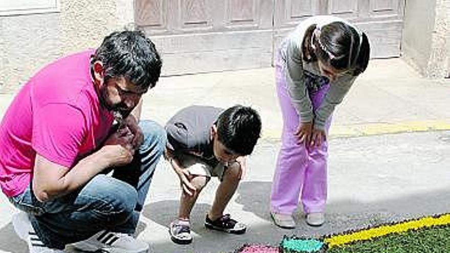 Una familia observa la alfombra de la calle del Campo.