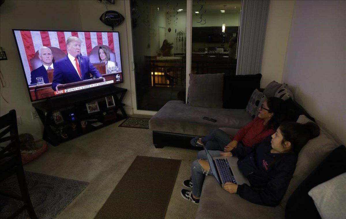 Maribel Solache, una inmigrante indocumentada de México, se sienta con su hija Valentina Castillo mientras observan al presidente Donald Trump dar su discurso.