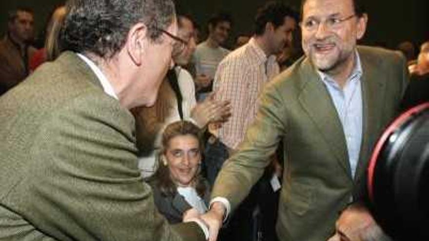 El presidente del PP, Mariano Rajoy  , saluda al alcalde de Madrid, Alberto Ruiz-Gallardón , momentos antes de su intervención en la clausura de la Conferencia sobre Educación.