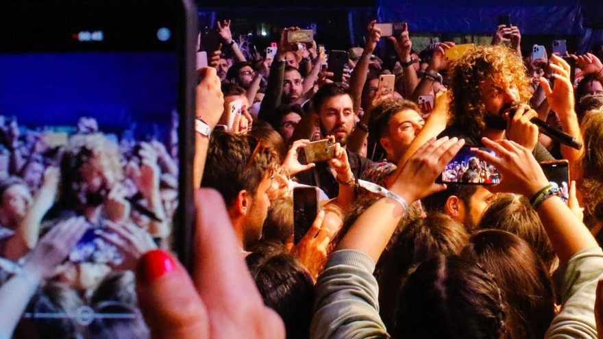 Mikel Izal cantando rodeado entre el público y los móviles durante su actuación en el Atlantic Fest.