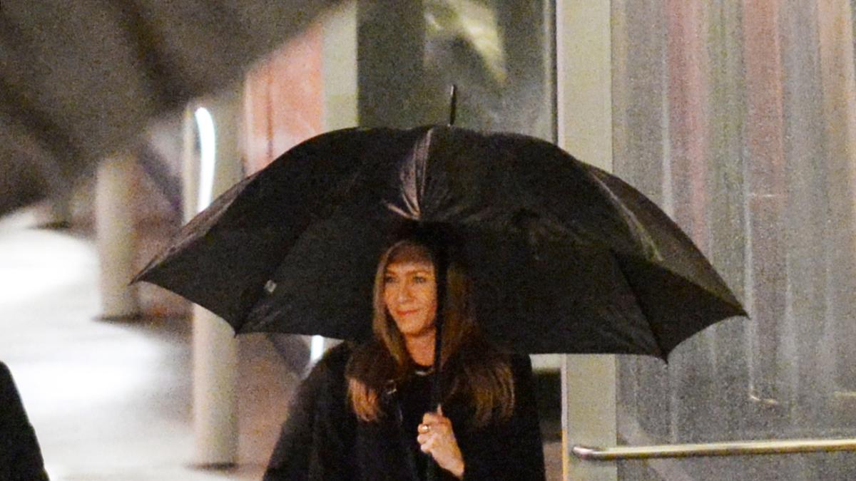 Jennifer Aniston con abrigo negro y zapatos animal print