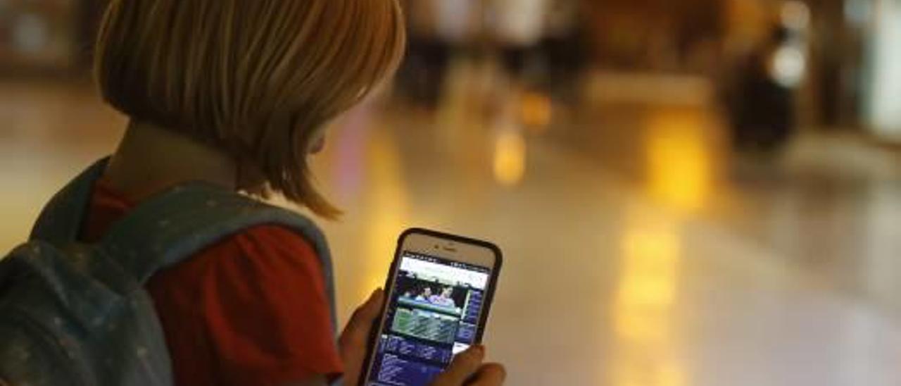 Un niña ojeando un portal de apuestas, que se publicita con sus ídolos de fútbol.