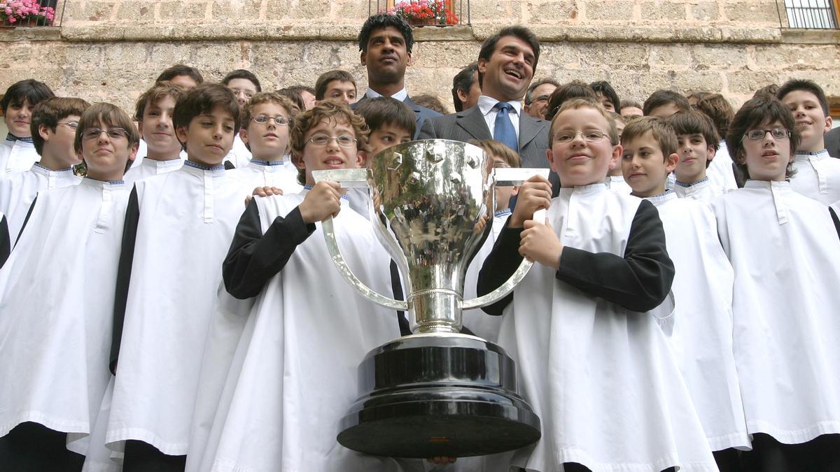 Frank Rijkaard y Joan Laporta, con los niños de la Escolania de Montserrat y el trofeo de Liga, en 2005