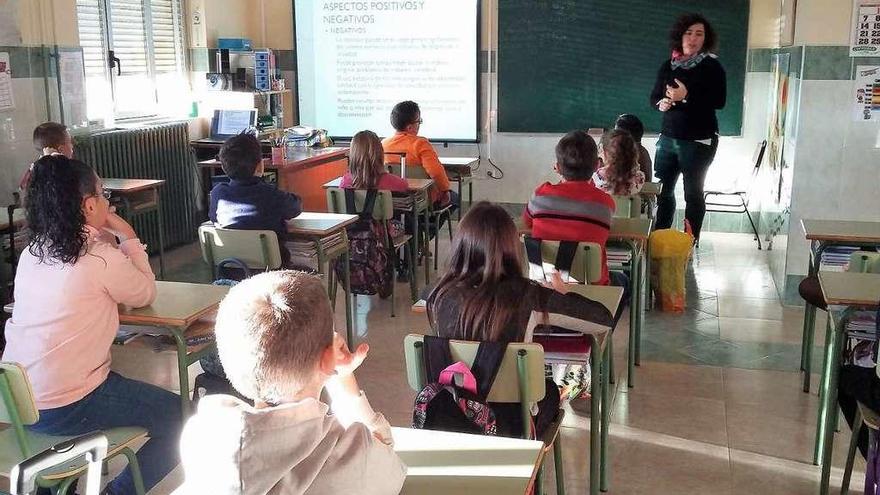 Varios alumnos atienden en el aula a las explicaciones de la profesora.