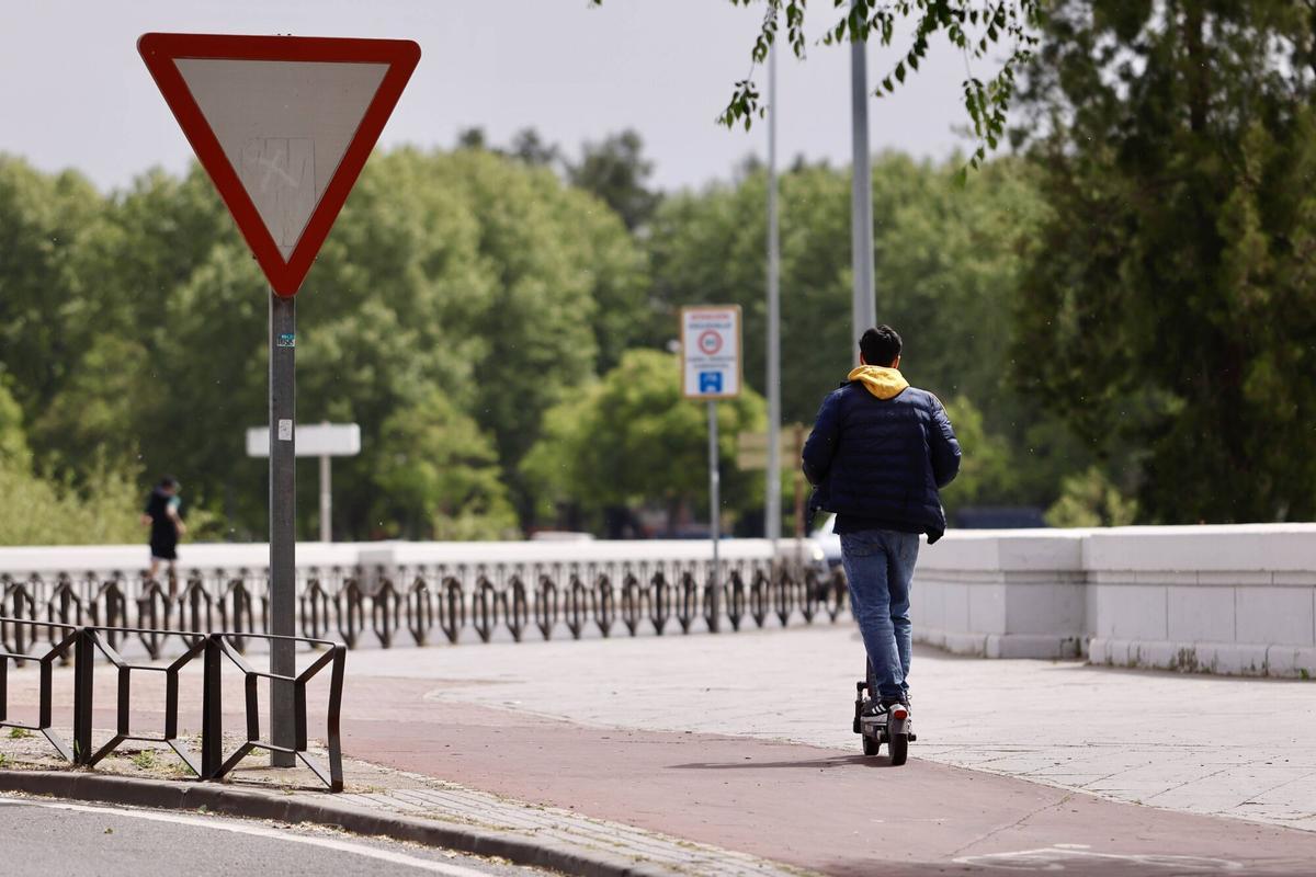 Un joven circula en patinete eléctrico por el puente de San Rafael.