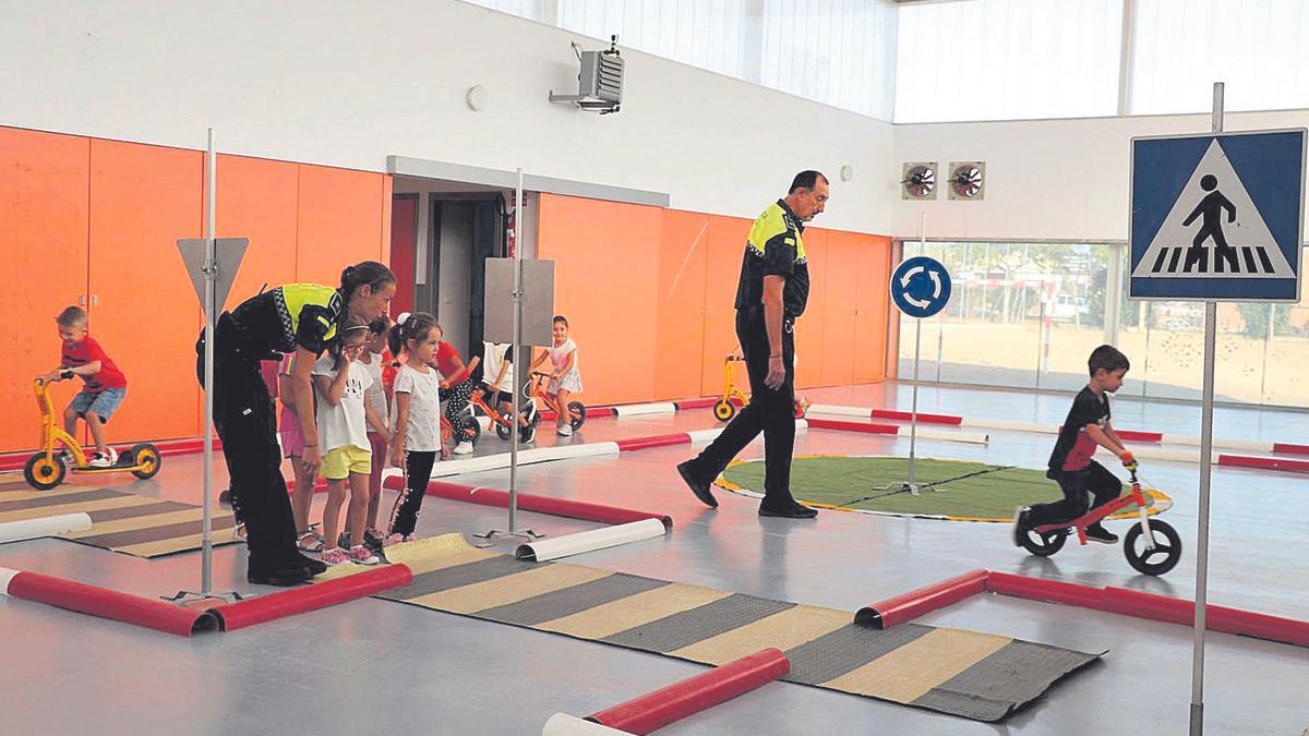 Agentes de la Policía Local instruyen a un grupo de niños sobre las normas que rigen cuando se circula en bicicleta.