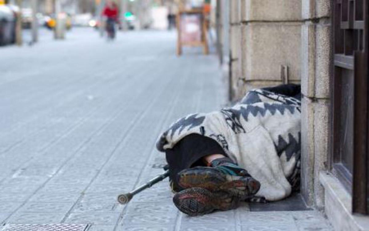 Una persona sin hogar duerme en una calle de la capital catalana.