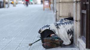 Una persona sin hogar duerme en una calle de la capital catalana.