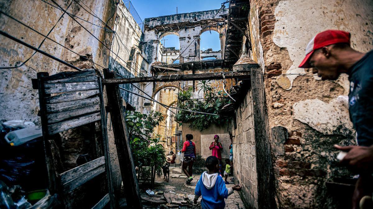 Isaac, hijo de Romilio (80), camina con otros residentes por las ruinas que quedan de su casa en la calle Cuba, 62, La Habana.