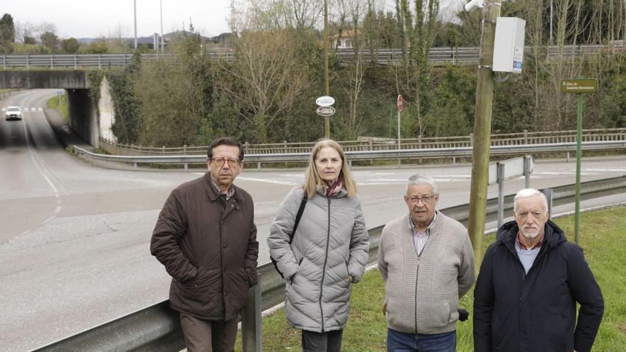 Por la izquierda, Andrés Alonso, Inmaculada Jiménez, José María Rubiera y Fermín Cachón, ayer, en el cruce entre la carretera de Castiello y la carretera de la Isla, delante de una de las cámaras de vigilancia instaladas. | JUAN PLAZA