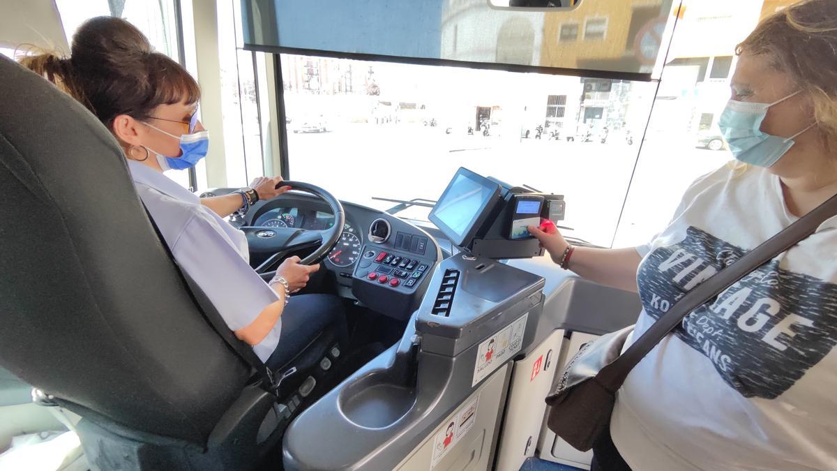 Una usuaria paga su viaje con un bonobús en un autobús urbano de Badajoz.