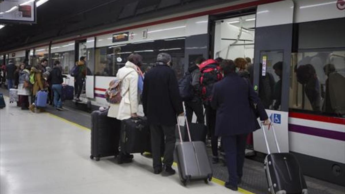 Unos pasajeros suben a un tren de Rodalies en la estación de Sants.