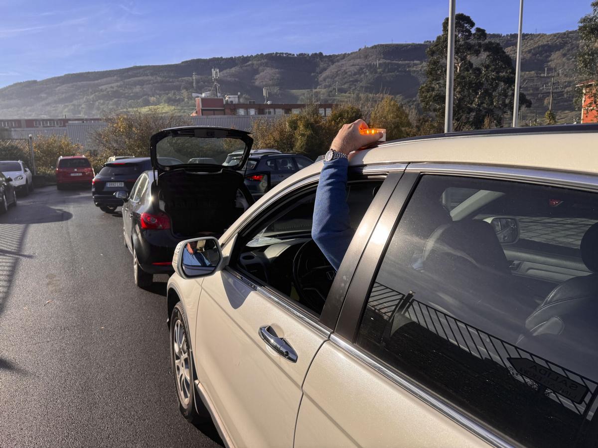Un conductor coloca una baliza de emergencias.