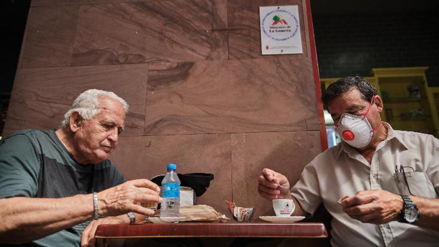 Dos hombres toman un café y agua en una terraza de San Sebastián de La Gomera.