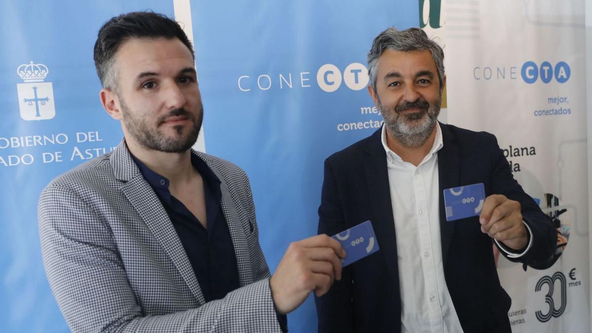 Por la izquierda, Jorge García y Alejandro Calvo, ayer, con la nueva tarjeta «Conecta», en el pabellón del Principado en la FIDMA.| Marcos León
