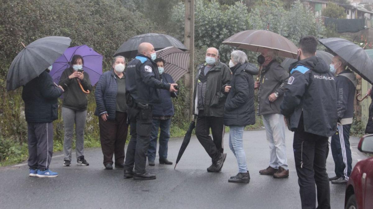 La Policía Local de Cangas conversa ayer con los vecinos que se oponían al paso del camión. |   // S.Á.