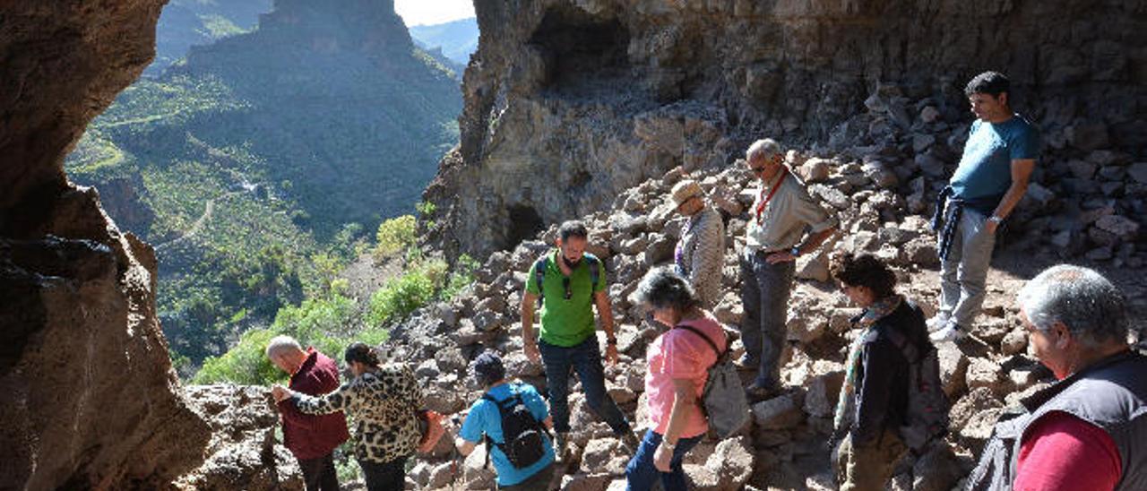 Un grupo de personas salen de la cueva túnel que une la ladera sur con la norte de La Fortaleza de Ansite.