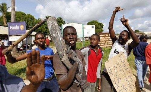 Residents chant slogans as they protest along the streets after unidentified gunmen recently attacked the coastal Kenyan town of Mpeketoni