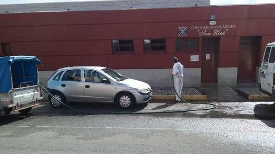 Trabajo de baldeo en la lonja de Cangas.