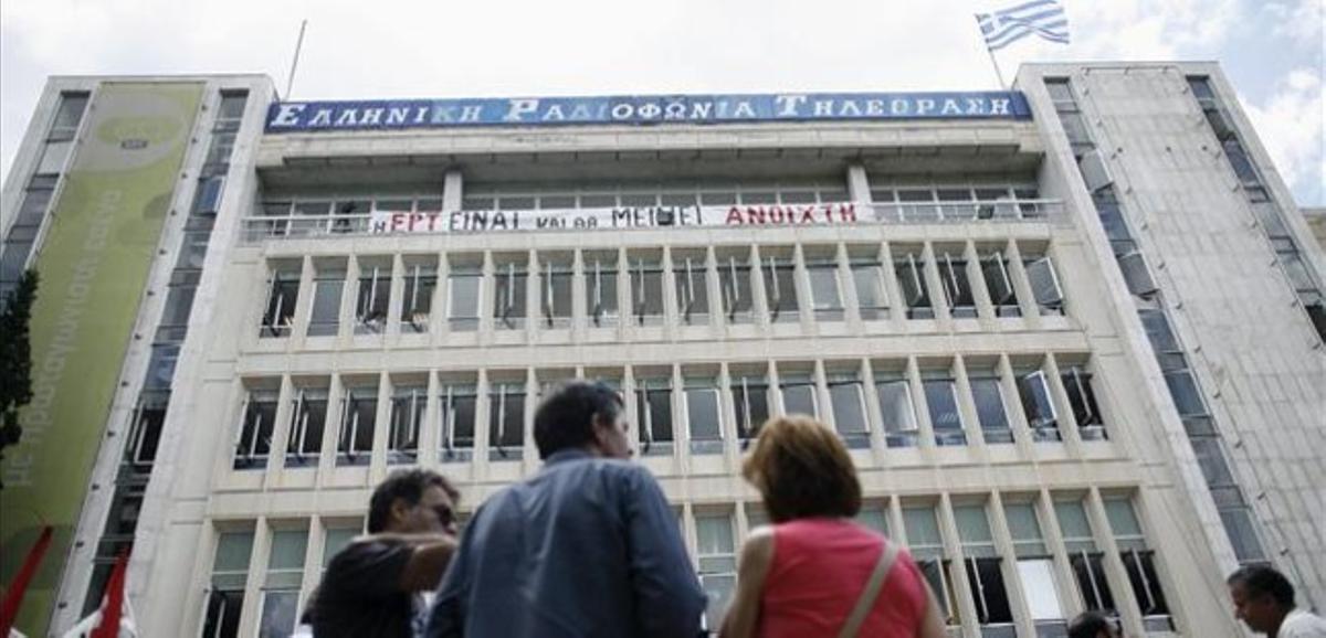 Tres treballadors d’ERT, a l’exterior de la seu de l’organisme, a Atenes.