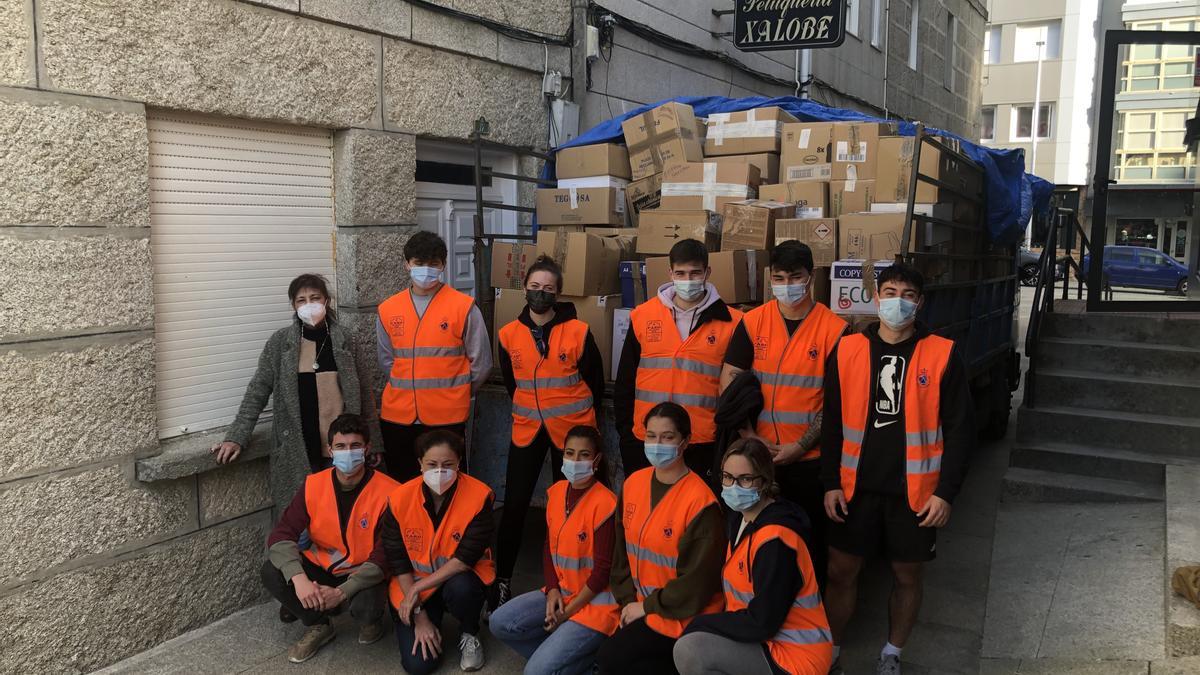 Voluntarios de Protección Civil con la mercancía y la concejala de Servizos Sociais de Baiona.