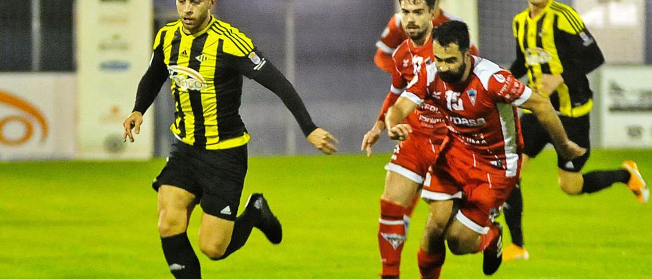 Rubén Cerqueiras, autor del único gol, conduciendo el balón perseguido por Pablo Mota. |  // I. ABELLA