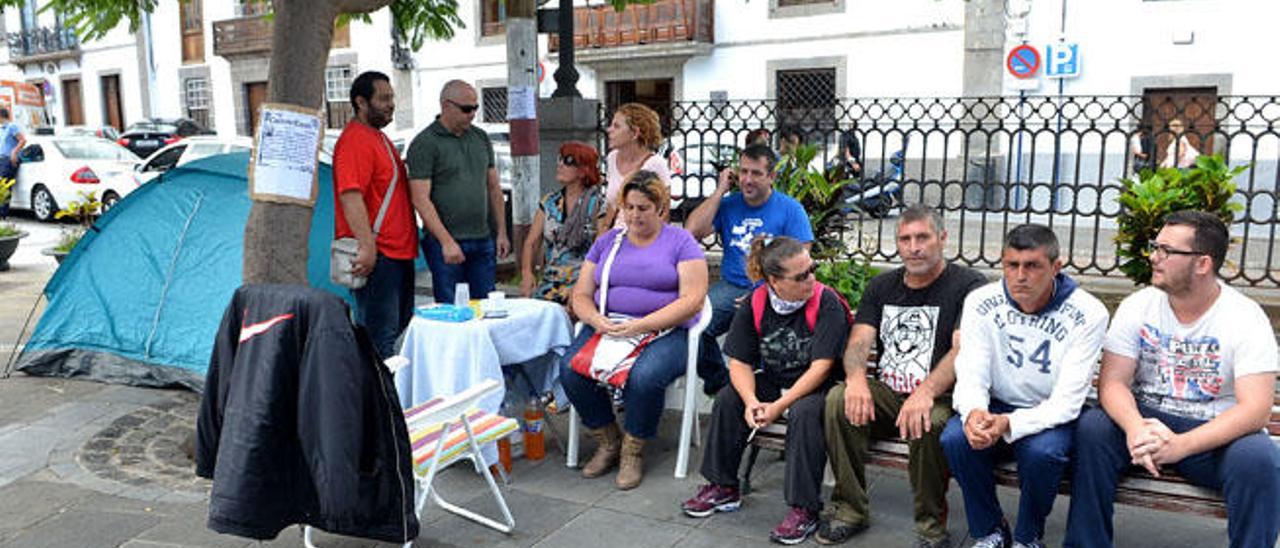 Santiago León y José Brito, en el centro del banco, acompañados ayer en la plaza de San Juan durante su huelga de hambre.