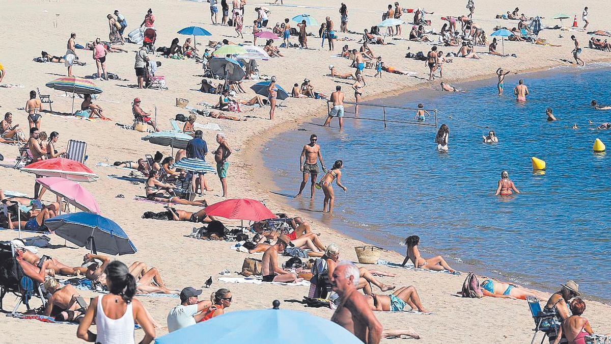 La platja de Sant Feliu de Guíxols, plena de banyistes el primer diumenge d'octubre.