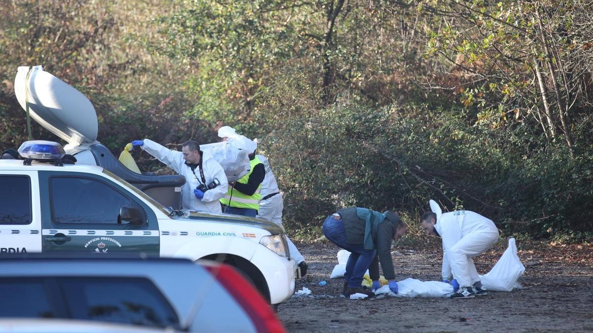 Los investigadores inspeccionando el contenido del contenedor tras el que apareció el cadáver.