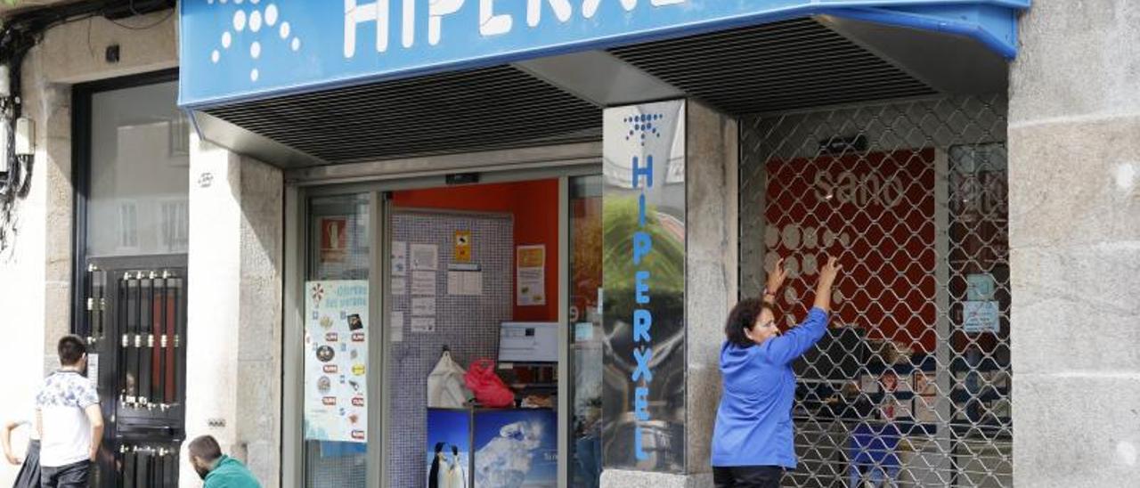 Una empleada de Hiperxel cerrando una de sus tiendas en Vigo.