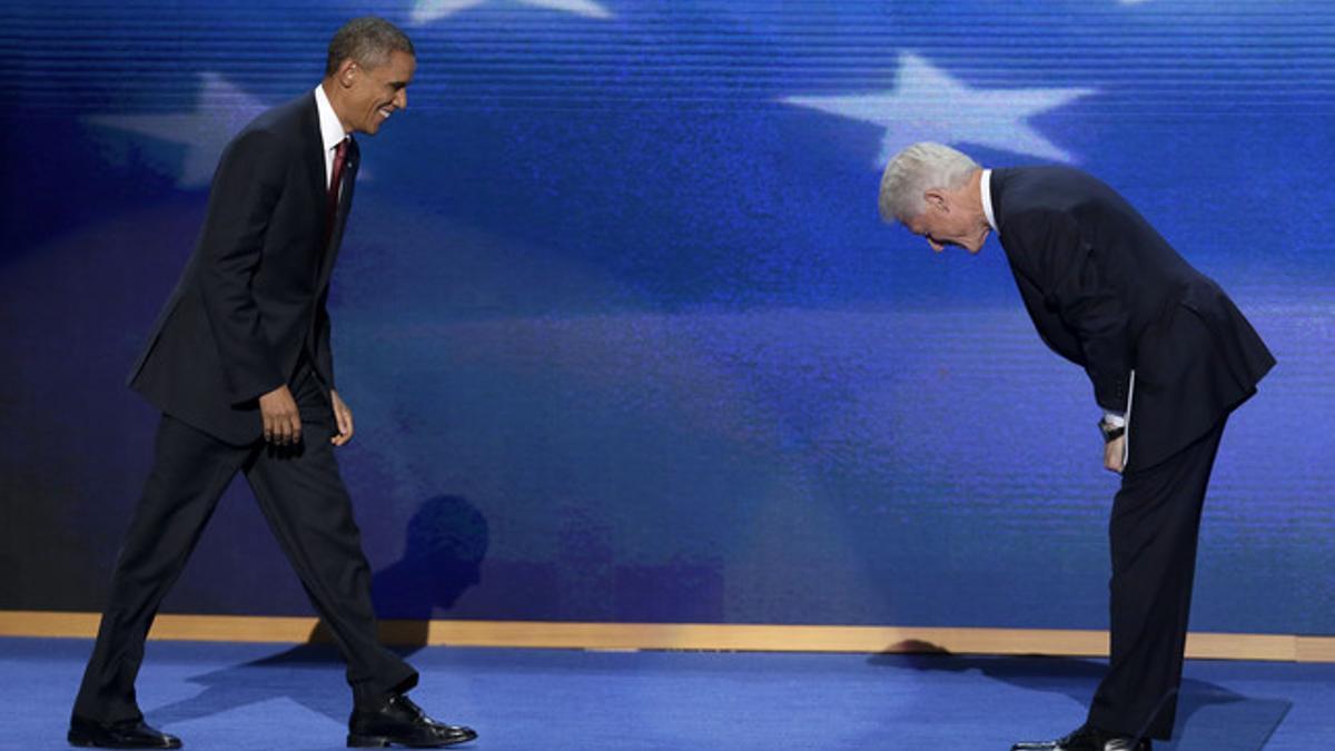 Bill Clinton se inclina ante la llegada de Barack Obama al escenario, anoche en Charlotte, durante la convención demócrata.