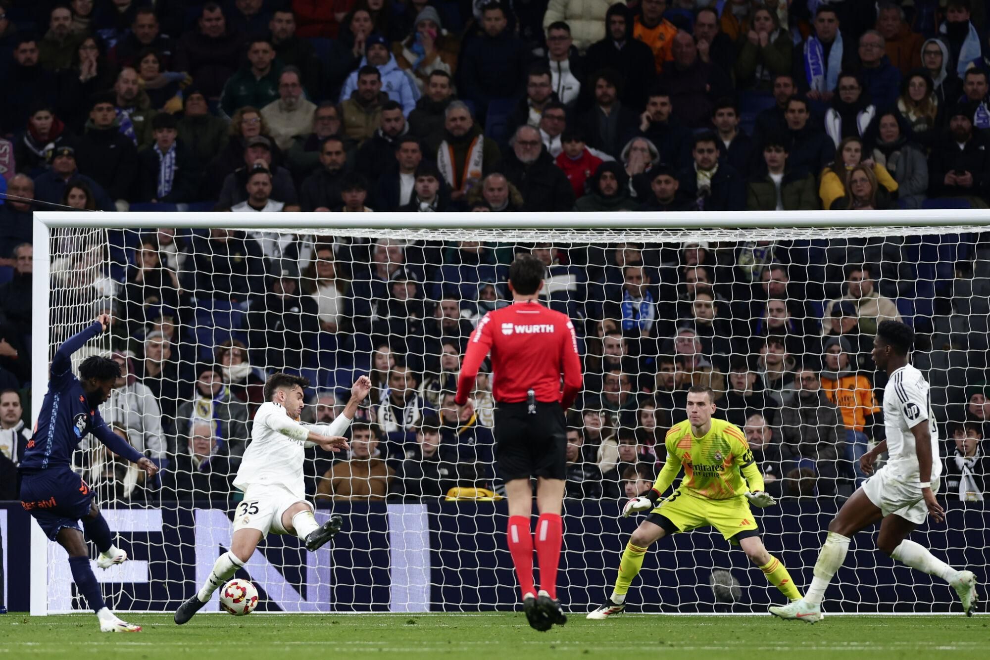 Celta's Jonathan Bamba, left, scores his side's first goal against Real Madrid during a Copa del Rey round of 16 soccer match at the Santiago Bernabeu stadium in Madrid, Spain, Thursday, Jan. 16, 2025. (AP Photo/Pablo Garcia)
