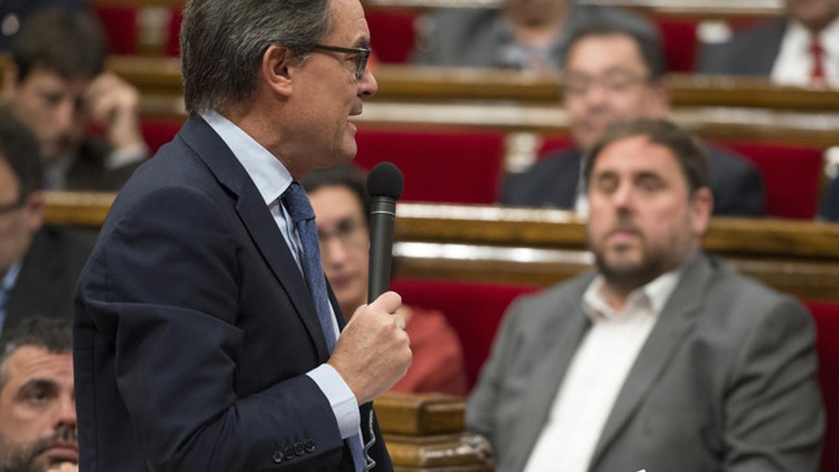 Artur Mas, observado por Oriol Junqueras, en el pleno del Parlament.