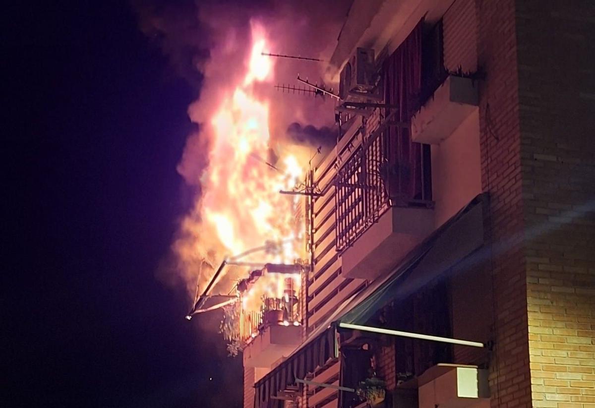 Las llamas salen con fuerza por el balcón de la vivienda de Cabra incendiada.