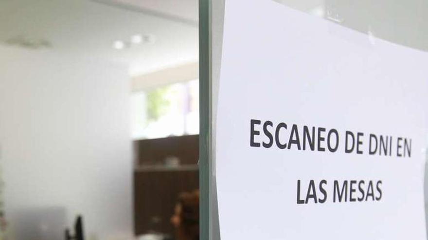 Un cartel de una oficina bancaria indica dónde escanear el DNI.