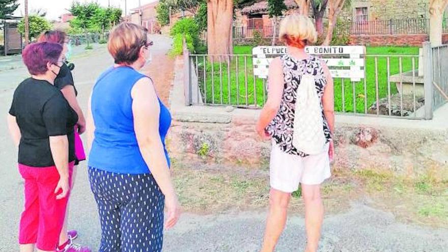 Varias mujeres de Villardiegua, junto a una de las señales instaladas. | Cedida