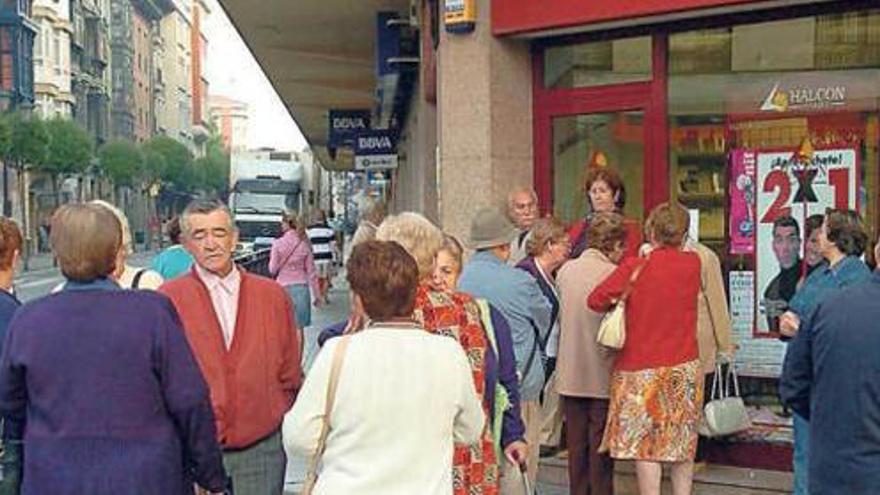 Varios jubilados, ante una agencia de viajes.