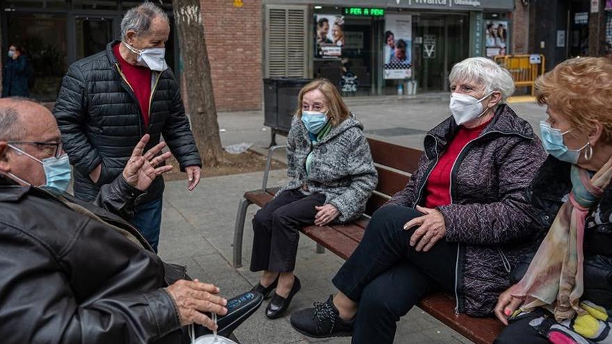 Un grupo de jubilados conversan en la calle.