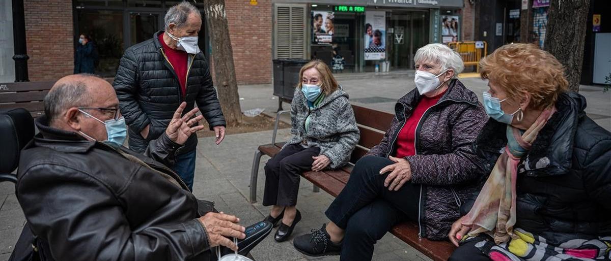 Un grupo de jubilados conversan en la calle.