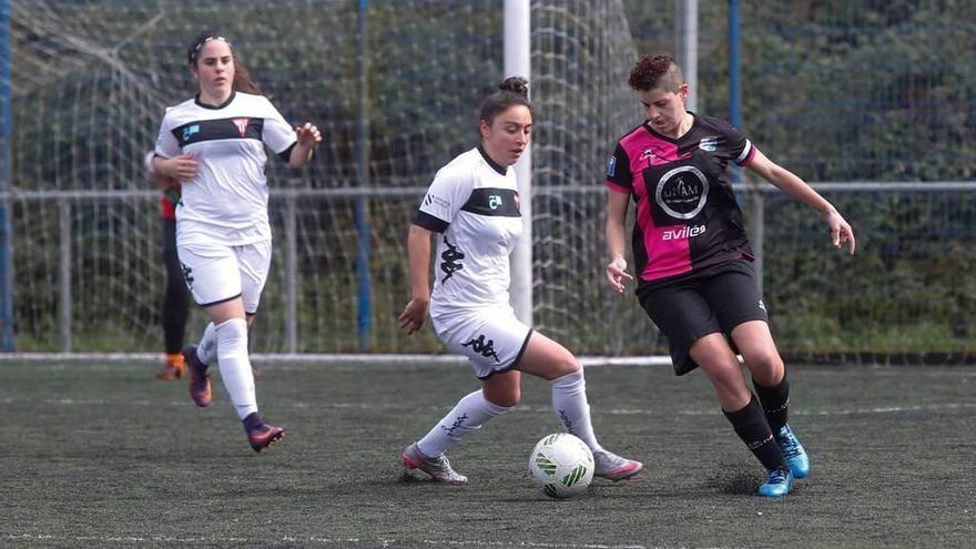 Dos jugadores del Victoria acosan a una centrocampista del Femiastur.