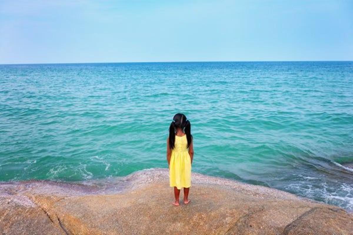Una niña mira hacia el mar en la playa Chaweng, en Ko Samui.