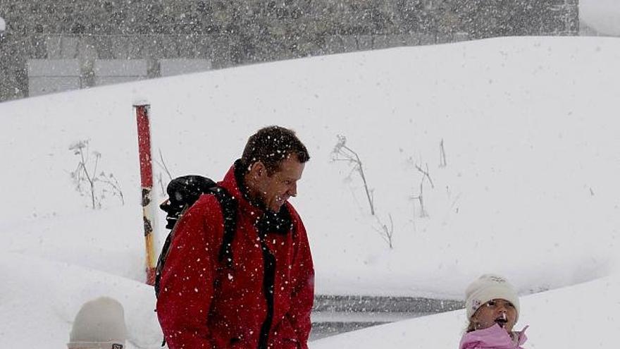 Un hombre con dos niños esta mañana disfrutan de la nieve en el puerto de Somport, en Huesca.