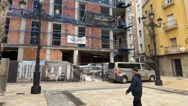 Un hombre pasa frente a un bloque de viviendas en construcción en Cartagena.