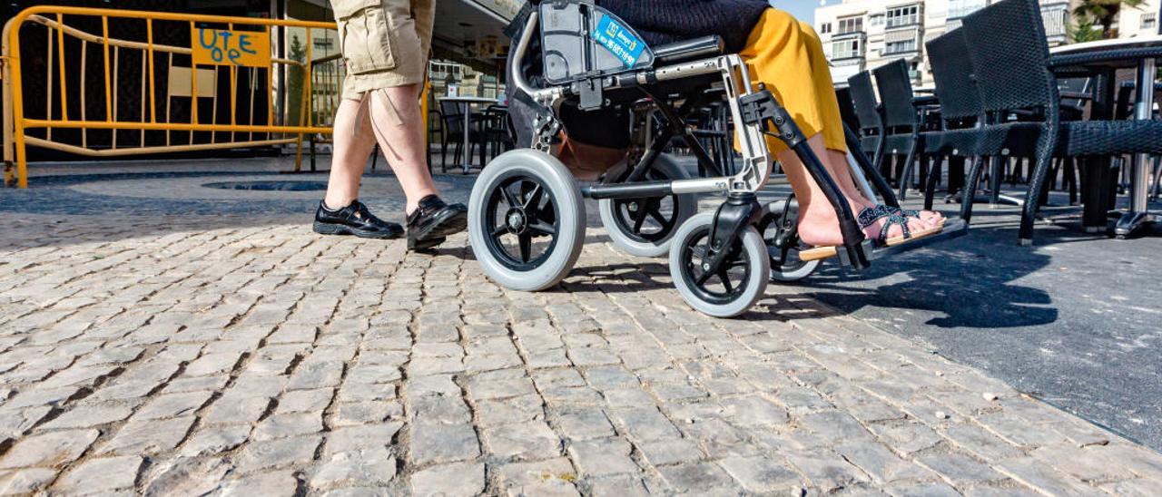 Usuarios con movilidad reducida, ayer, a su paso por la nueva plaza Triangular de Benidorm.