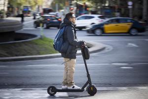 Un hombre circula en patinete por Barcelona.