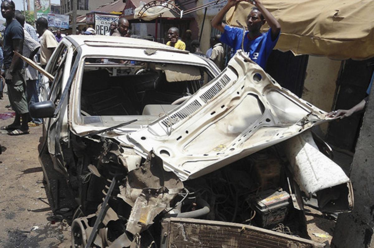 Un coche calcinado, tras la explosión frente a la redacción del periódico nigeriano ’This Day’, donde dos suicidas han acabado al menos con la vida de tres personas.