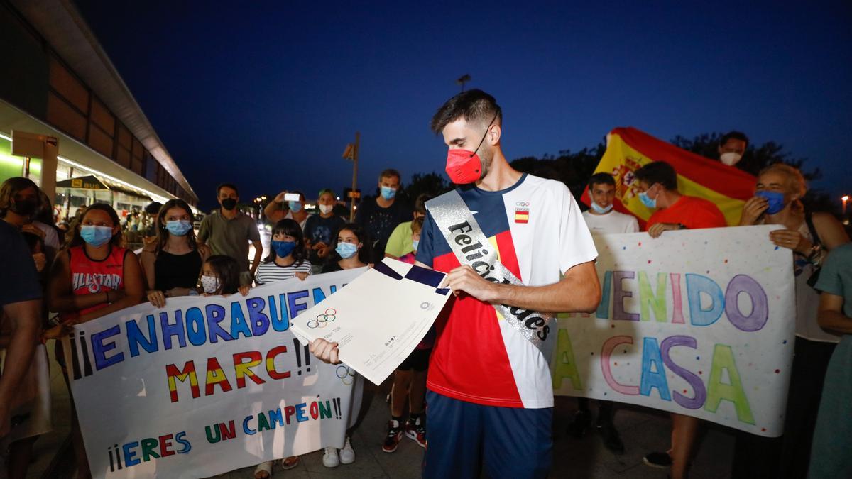 Marc Tur, rodeado de familiares, amigos y aficionados de la isla, muestra el diploma olímpico conseguido en los 50 km marcha.